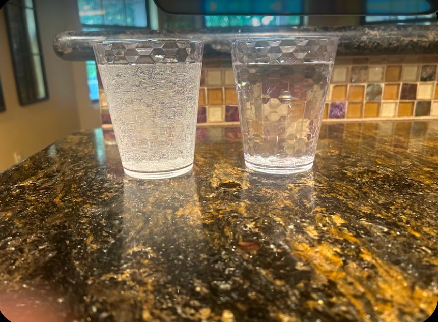 Real Fresno customer photo: cloudy tap water next to clear water after Nick's install